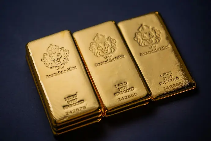 Three gold bars sitting next to each other on a table